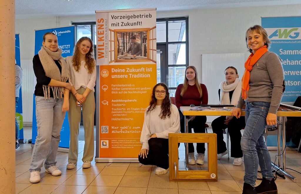 Beatrix Wilkens mit Schülerinnen des Gymnasiums Bruchhausen-Vilsen vor dem RollUp Banner des Projekts Digitale Lernallianz