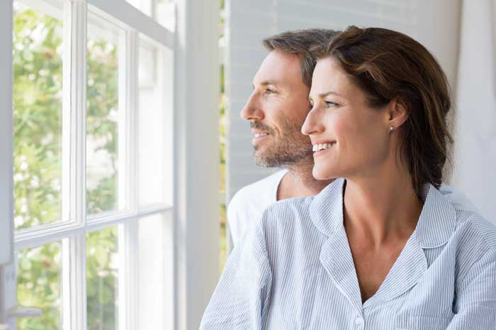 Mann und Frau schauen aus Sprossenfenster